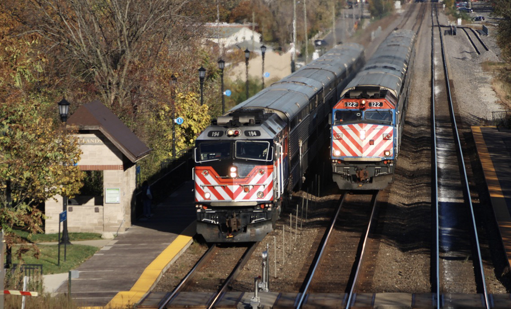 Two commuter trains side-by-side on three-track main line