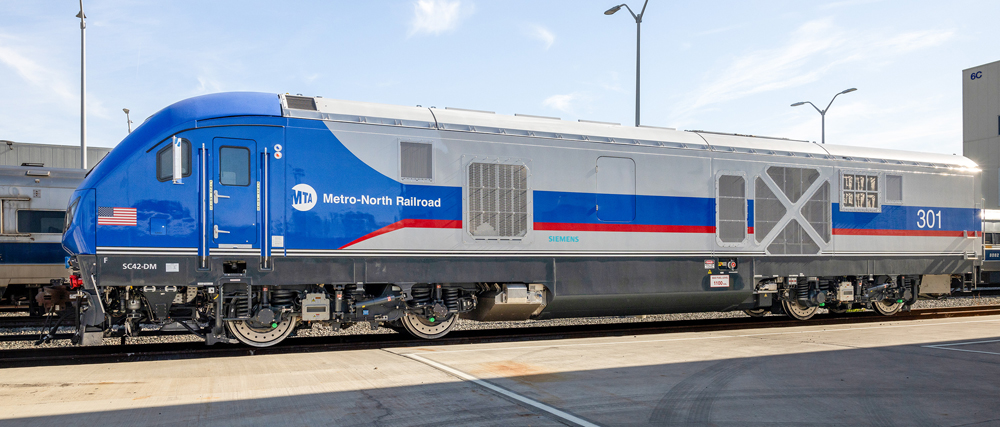 Side view of blue and silver locomotive with red trim stripe