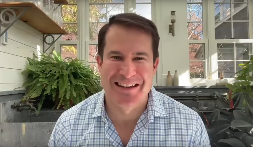 Man in casual clothing with house in background