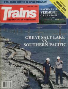 Cover of magazine with two men standing on wavy railroad tracks partially in water