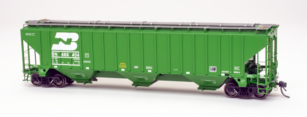 Color photo of HO scale three-bay covered hopper painted green on white background.