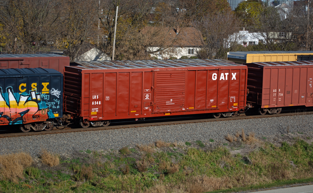 Color photo showing six boxcars in different paint schemes.