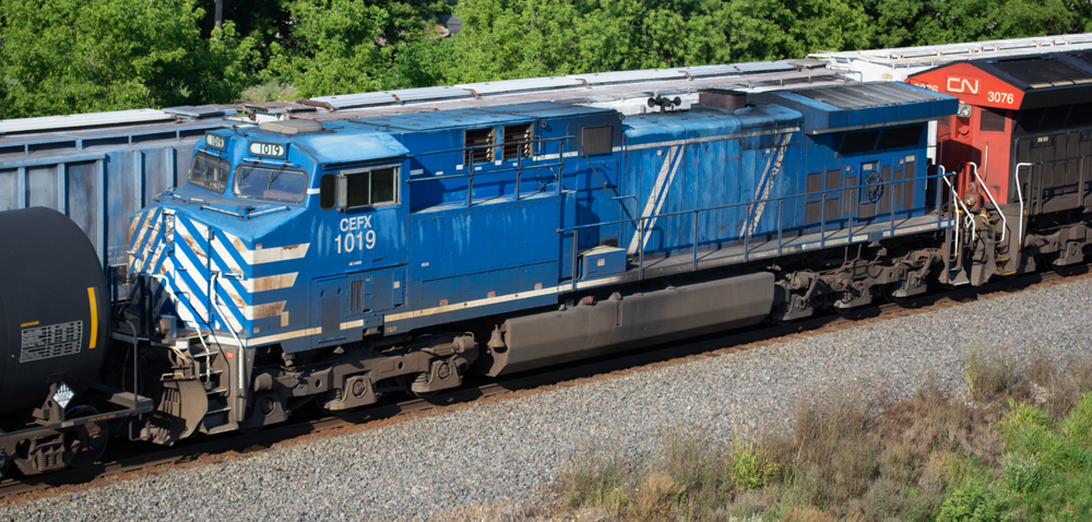 Color photo of blue and white locomotive in a freight train.