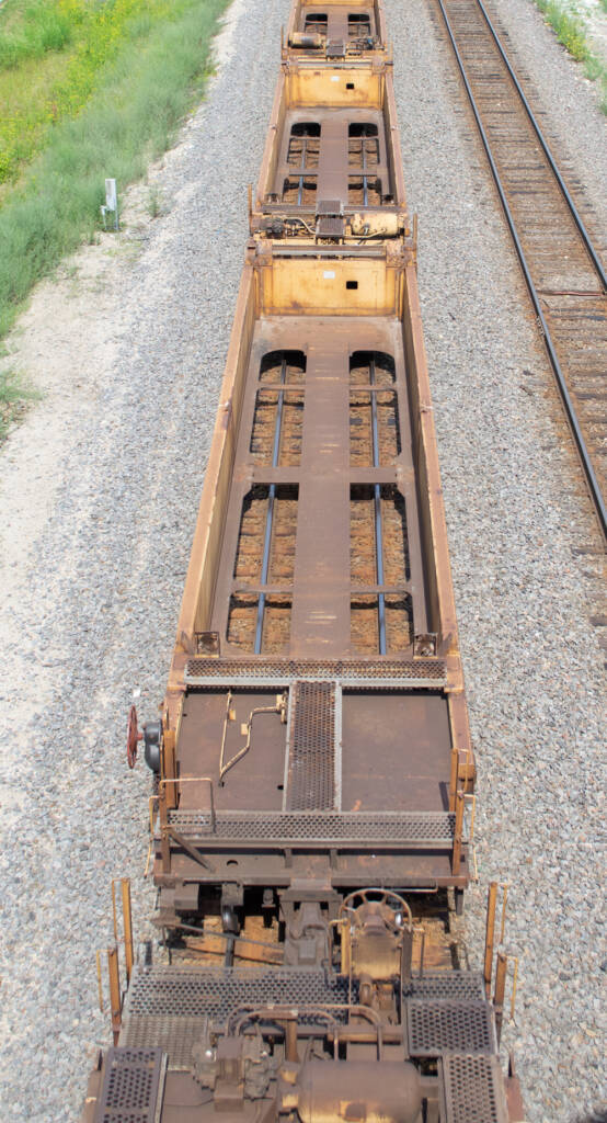 Color photo showing interiors of empty well cars.