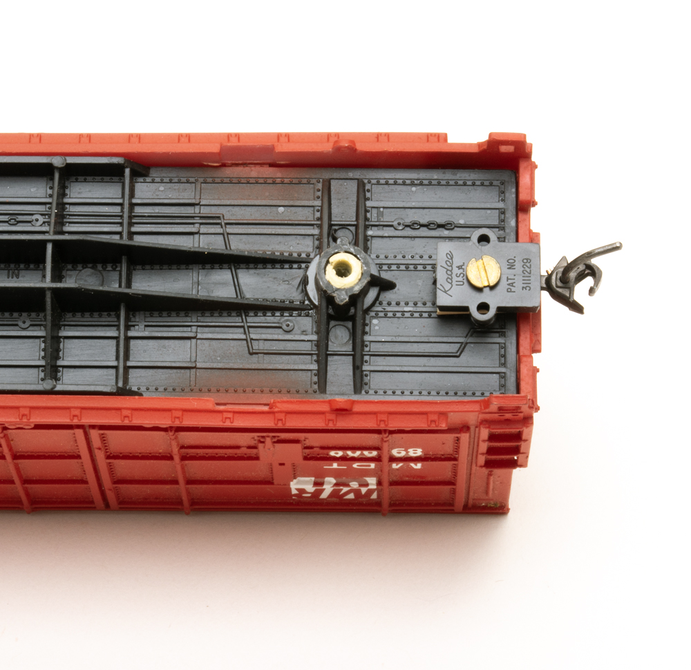 Color photo showing underside of red HO scale freight car with black underbody.