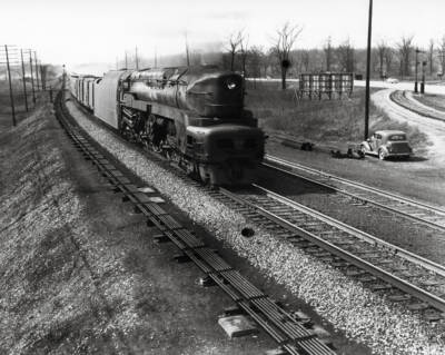 Streamlined steam locomotive with a freight train.