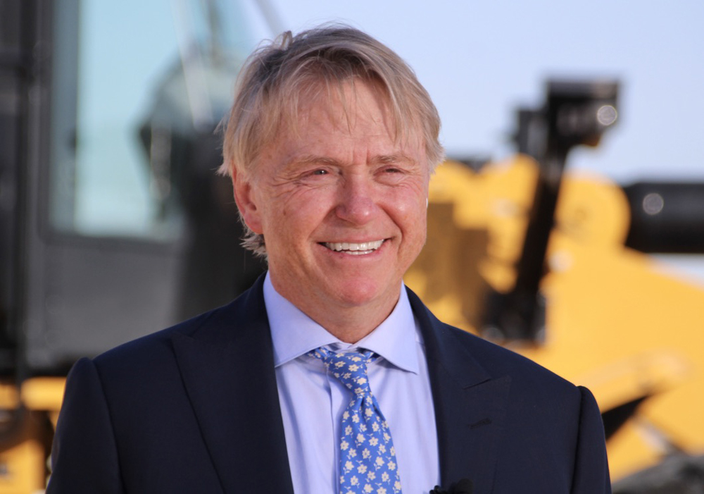 Man in dark suit with blue shirt and tie