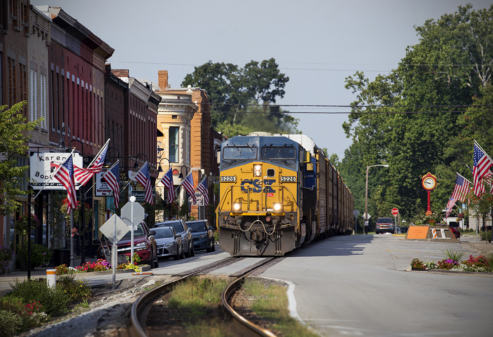 Freight train running down street of small town