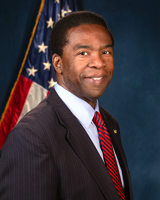 Head shot of man standing in front of American flag