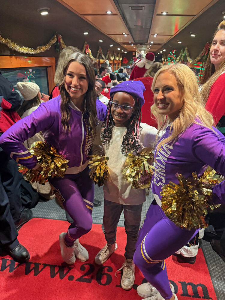 Two young women in purple flanking child