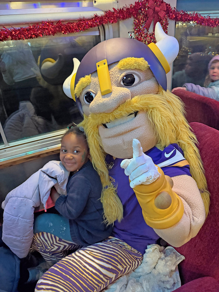 Person wearing giant foam Viking head with small girl