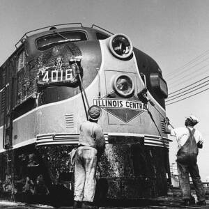 Men washing front of streamlined diesel locomotive