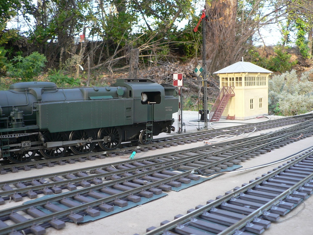 steam locomotive next to small yellow structure