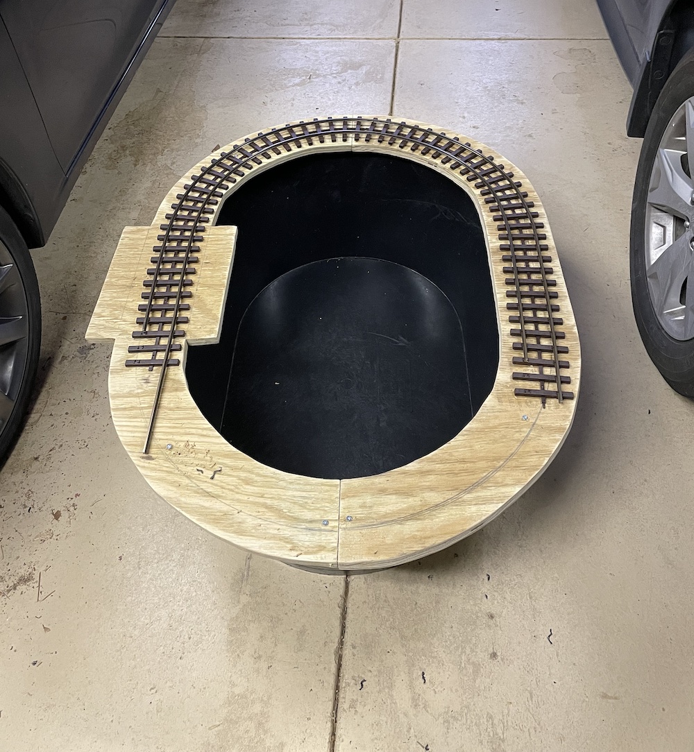 water tank with piece of plywood and track on top