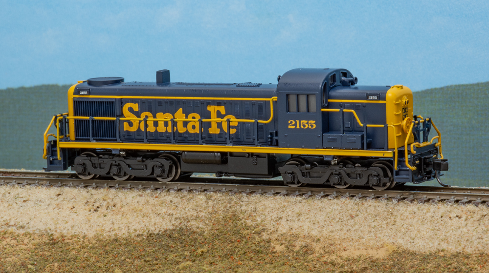 Color photo of blue and yellow N scale diesel on scenic base.