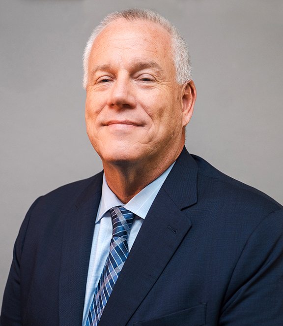 Head shot of gray-haired man in suit and tie