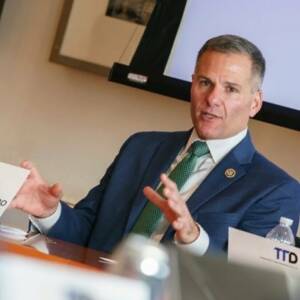 Man in suit gesturing at conference table