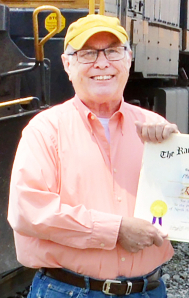 Man in baseball cap holding certificate