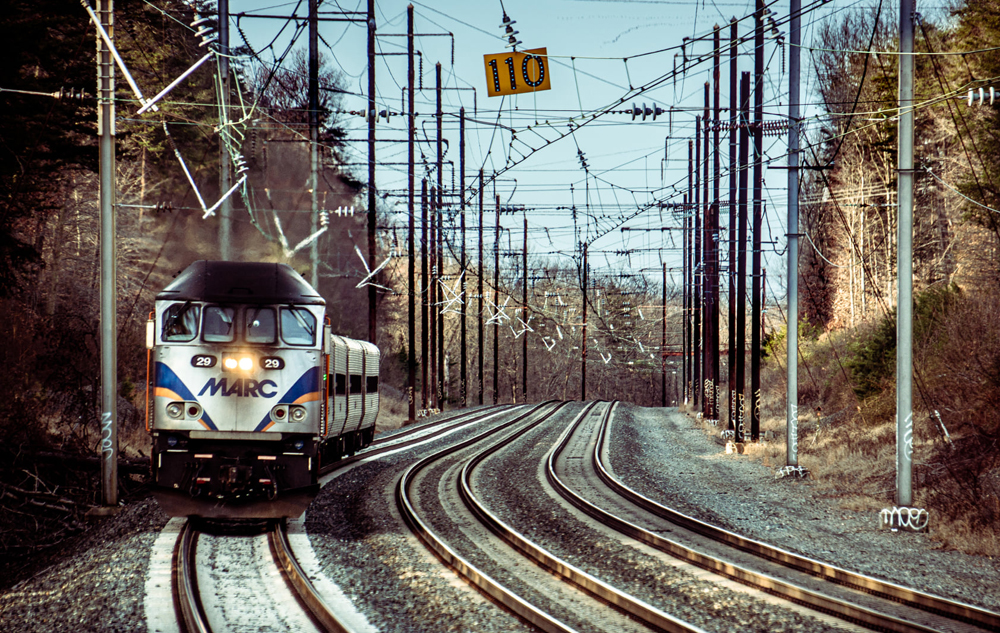 Commuter train with diesel locomotive on electrified line