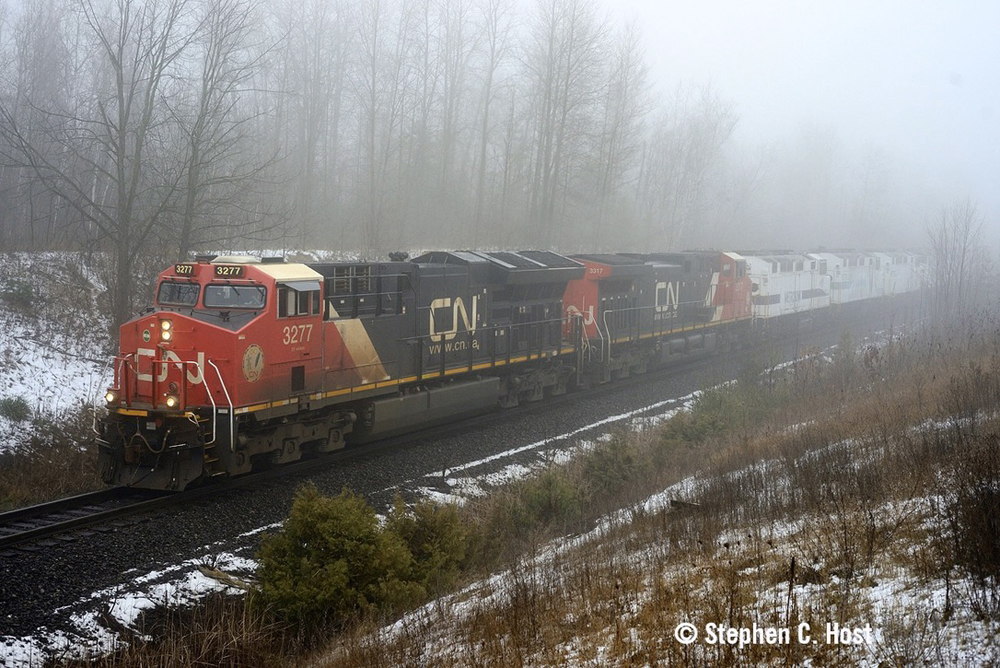 CN train in fog with former commuter engines behind freight locomotives