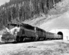 Square diesel locomotive with passenger train exiting tunnel