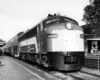 Streamlined diesel locomotive with passenger train at brick station