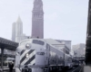 Silver-and-black diesel locomotive with passenger train at station with tower