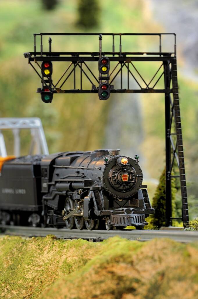 model train with signal bridge above it