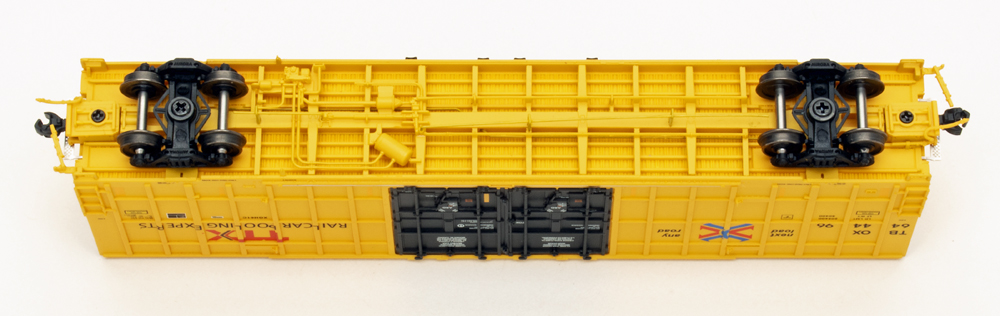 Color photo showing underbody of N scale boxcar in yellow paint. 