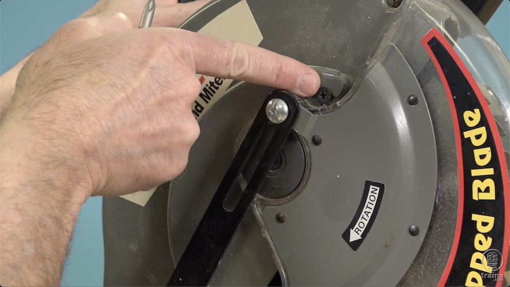 Finger point towards screw in a circular saw.