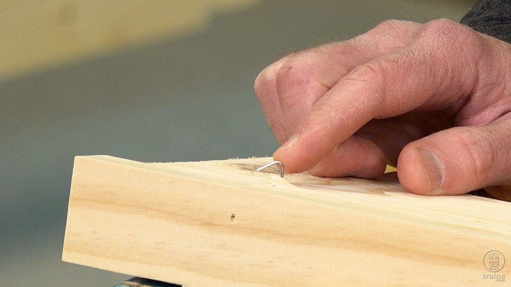 Close-up of nail head sticking out of a wood board.