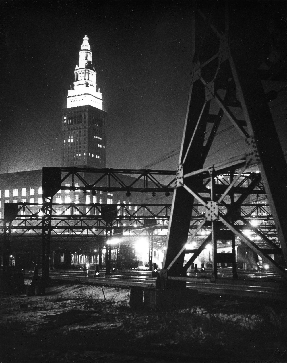 Tall building at night with electrified trains in foreground. Invisible Giants — inside the Van Sweringen brothers empire.