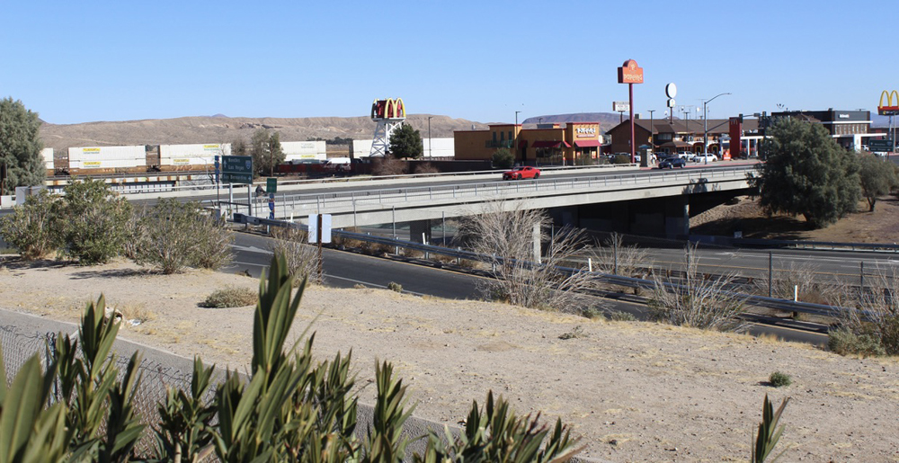 Bridges over highway, one carrying intermodal train