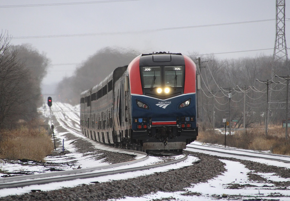 Passenger train in area with small amount of snow on the ground