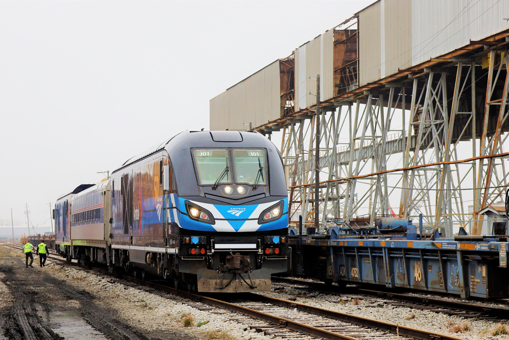 Train of two locomotives and one passenger car stopped on siding