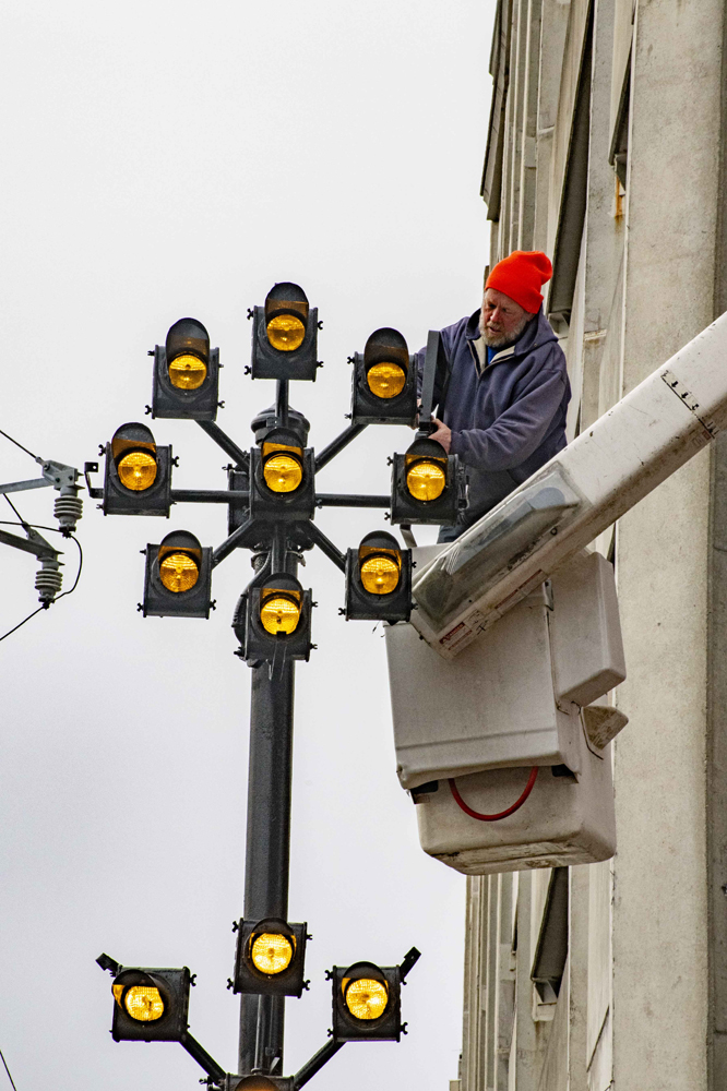 Man in cherry-picker basket working on restoration of railroad signal