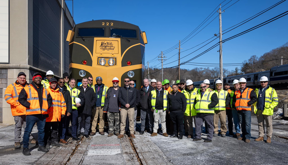 People posed in front of locomotive