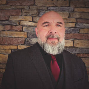 Head-and-shoulders shot of man bearded man in suit