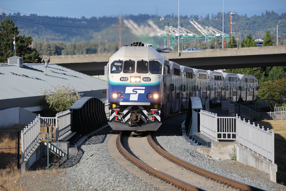 Commuter train climbing with city in background