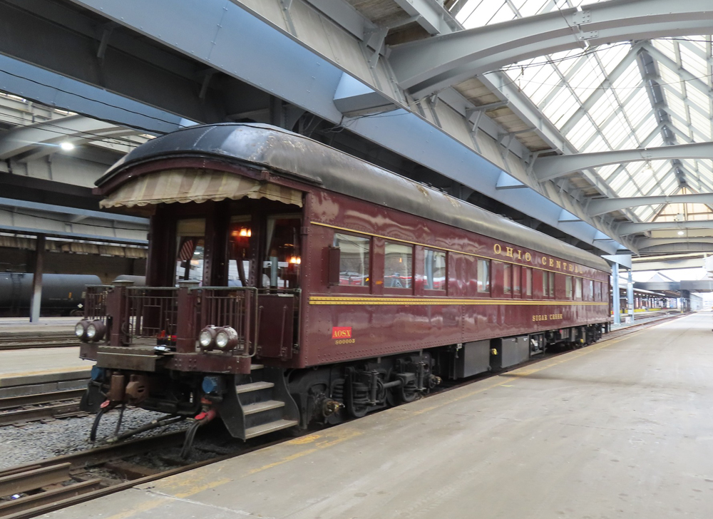 Tuscan red private car with end platform under station trainshed