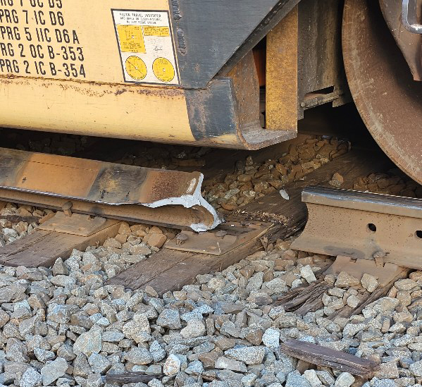 Broken rail under derailed container car