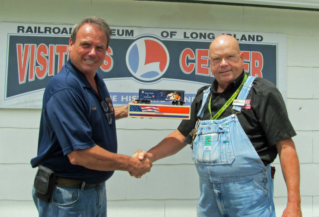 two men shaking hands with Lionel boxcar