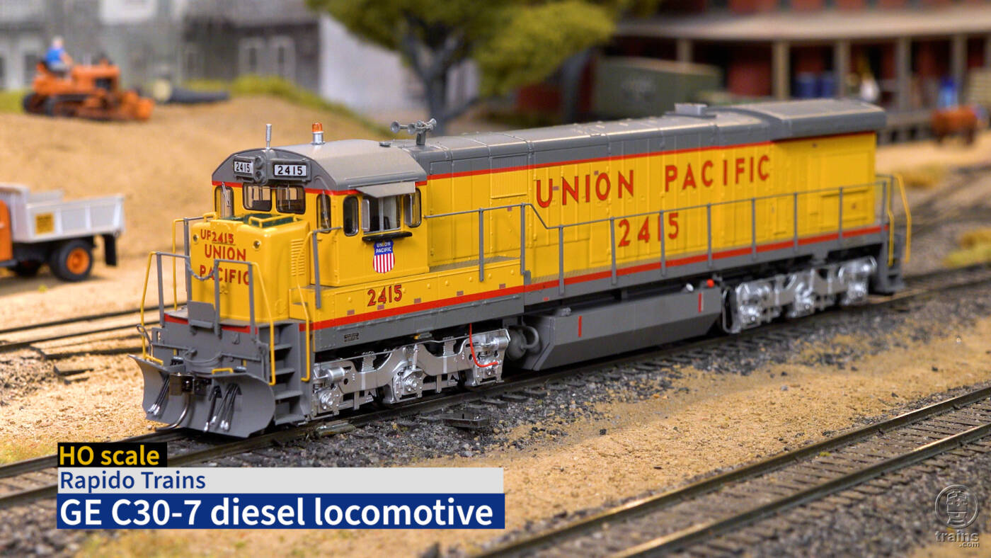 Screen shot from video with HO scale diesel on scenicked model railroad and title bar in lower left corner.