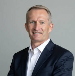 Head shot of man in dark coat and white shirt