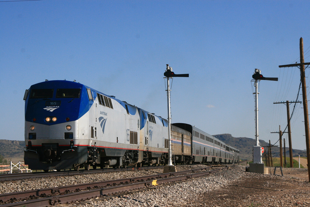 Passenger train with bilevel cars passing semaphore signals