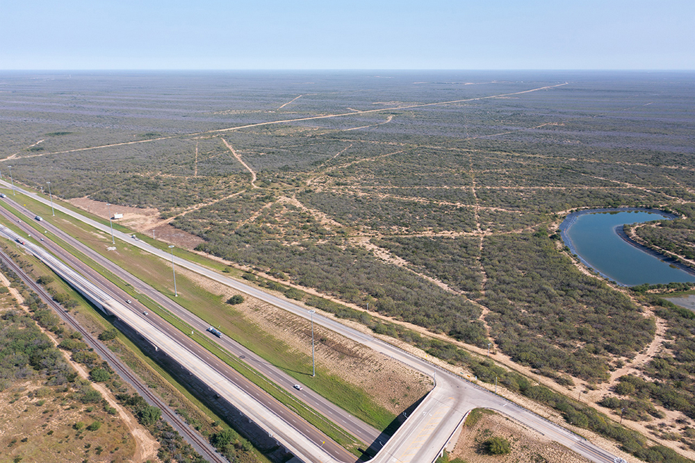 Aerial view of vacant land next to interstate highway and rail line