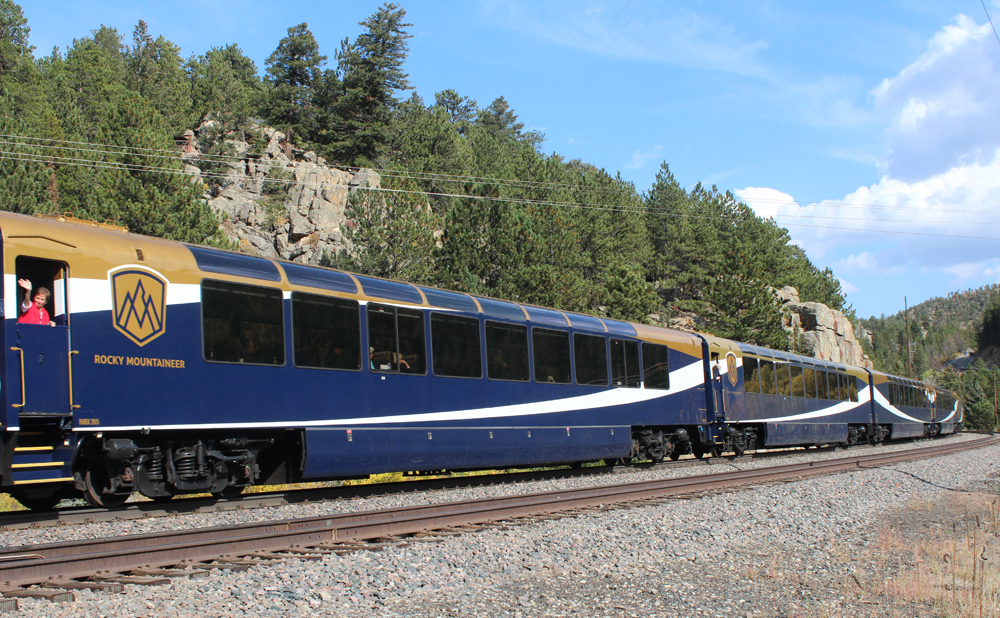 Blue passenger cars with white and copper trim in mountains