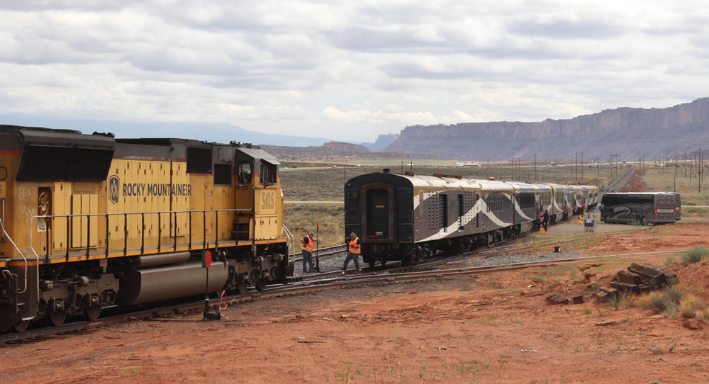 Passenger train at isolated siding with buses waiting for passengers