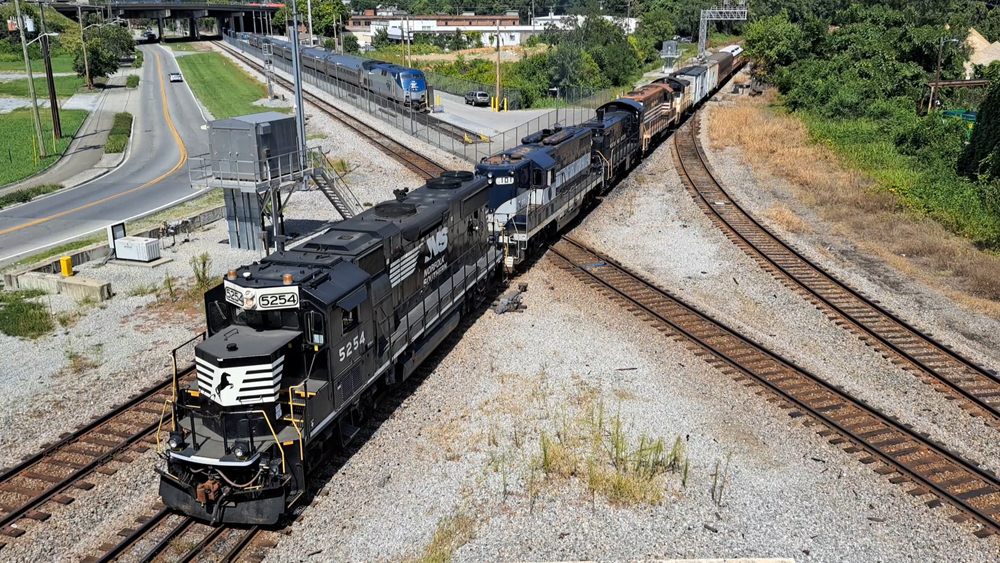 Black locomotive pulling historic rail equpiment