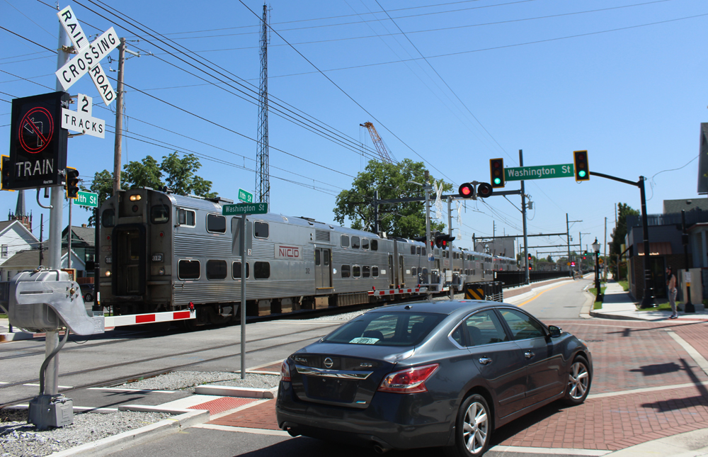 Commuter train running alongside city street